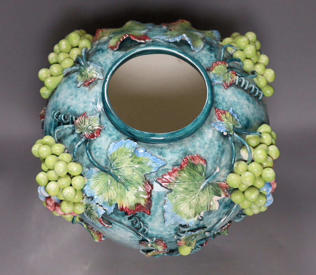 A large late 19th/early 20th century Continental polychrome glazed ‘grape vine’ vase, 39cm tall